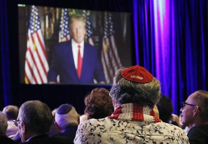 Un asistente a la reunión de la Coalición Judía Republicana escucha a Donald Trump.