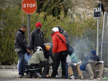 Un grupo de inmigrantes se calienta en una hoguera, ayer, en una calle de Jaén.
