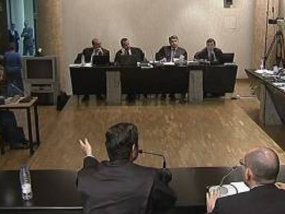 Imagen de televisión del momento de la expulsión de la preferentista (iz, al fondo) multada ayer por alterar el orden en el juicio, celebrado en el Tribunal Superior de Justicia de Madrid, al magistrado Elpidio José Silva. El presidente de la sala, Arturo Beltrán, que ya había advertido de que procedería a imponer sanciones si se alteraba el orden, ordenó su expulsión y multó a la mujer con 100 euros por alteración del orden. EFE/EFE-TV