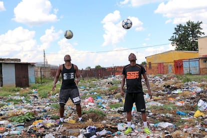 Dos jóvenes hacen malabares durante una actuación del colectivo de artistas Street Arts Government, en Sharpeville.