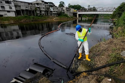 Un trabajador de la petrolera estatal limpia el río Viche en Ecuador, el 15 de marzo de 2025.