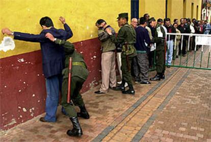 Unos militares colombianos registran a unos votantes antes de entrar en el colegio electoral.