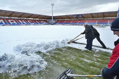 Operarios retiran la nieve en el estadio de Los Pajaritos de Soria, donde jugará el Madrid el domingo.