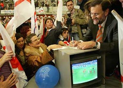 Mariano Rajoy firma autógrafos antes de comenzar el mitin en el que ayer participó en Barcelona.