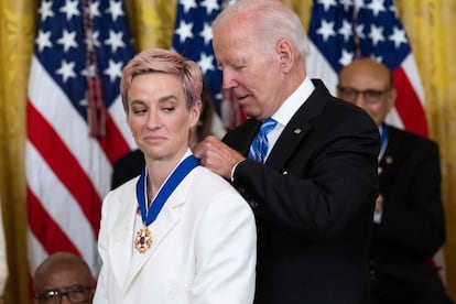 El presidente de Estados Unidos Joe Biden pone Megan Rapinoe la medalla presidencial de la Libertad.