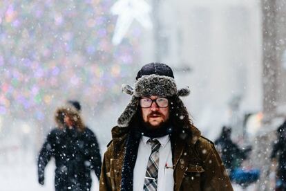Peatones caminan bajo la nieve un frío día de invierno en Nueva York (EE UU).