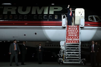 Donald Trump saluda desde su avión en 2016.
