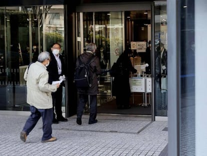 Varias personas entran en la sede de Toshiba en Tokio. 