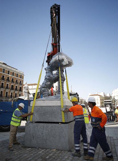 Unos operarios instalan la estatua del Oso y el Madroño, anteriormente ubicada en la calle del Carmen, en su nueva ubicación en la confluencia de Carrera de San Jerónimo y Alcalá.
