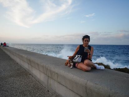 Dayamis Ramirez, de 25 años, navega en Internet en el Malecón de La Habana, Cuba, el 7 de febrero 2023.