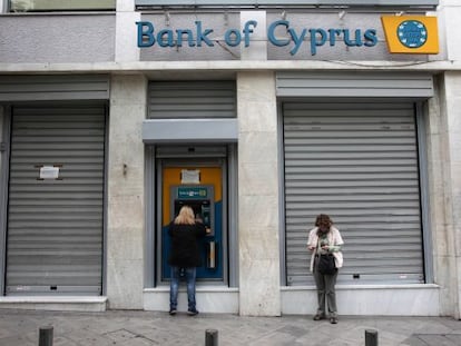 Clientes del Banco de Chipre, en el cajero de una sucursal cerrada.