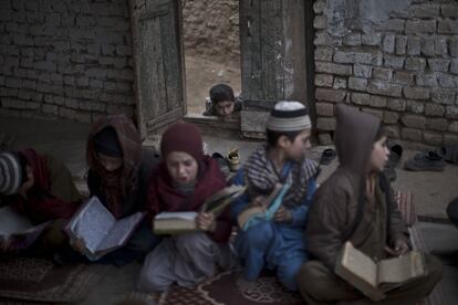 Un ni?o refugiado afgano se asoma por una puerta de una mezquita donde un grupo de chicos ms mayores asisten a la Madraza o escuela islmica, en las afueras de Islamabad, Pakistn.