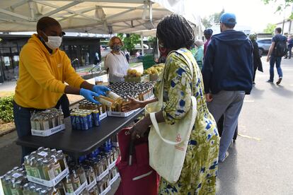 Un voluntario entrega alimentos a una mujer durante el reparto de este viernes. 