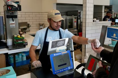 An employee collects payment at an Auntie Anne's and Cinnabon store in Livermore, Calif., Thursday, March 28, 2024.