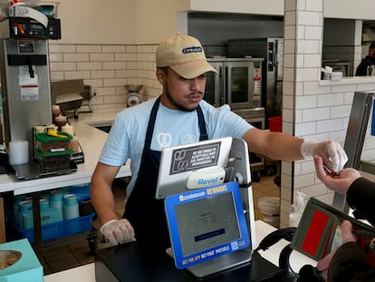 An employee collects payment at an Auntie Anne's and Cinnabon store in Livermore, Calif., Thursday, March 28, 2024.