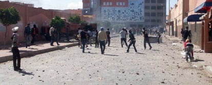 Manifestantes arrojan piedras durante el estallido de violencia en El Aaiún tras el asalto marroquí al campamento saharaui.