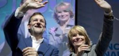 El presidente del PP, Mariano Rajoy, y la presidenta madrileña, Esperanza Aguirre, saludan durante la clausura una convención regional del partido en Madrid.