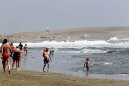 Varios turistas pasean por la playa de Maspalomas, en el sur de la isla de Gran Canaria. EFE/Archivo