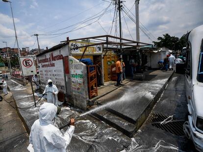 Trabajadores municipales desinfectan las calles del barrio de Petare, en Caracas.