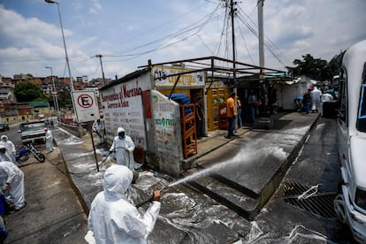 Trabajadores municipales desinfectan las calles del barrio de Petare, en Caracas.