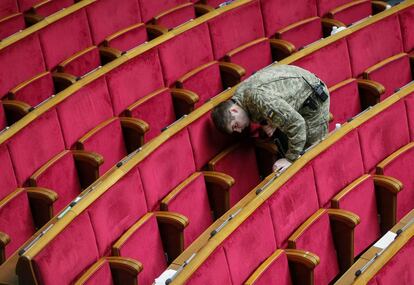 Un militar del Servicio de Seguridad de Ucrania comprueba la sala del Parlamento antes de una sesión, en Kiev (Ucrania).