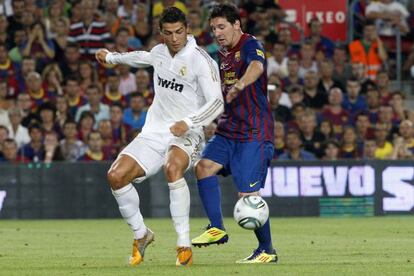 Messi lucha por el balón con Cristiano durante un Barça-Madrid