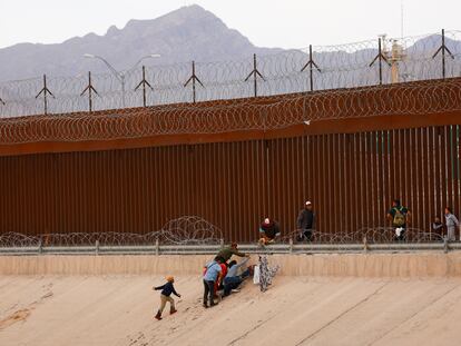 Migrantes intentan cruzar una valla de alambre de púas desplegada junto al muro en la frontera con Estados Unidos, en Ciudad Juárez (México), el 4 de junio.