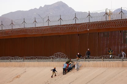 Migrantes intentan cruzar una valla de alambre de púas desplegada junto al muro en la frontera con Estados Unidos, en Ciudad Juárez (México), el 4 de junio.