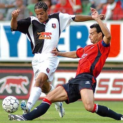 El defensa de Osasuna César Cruchaga intenta parar al jugador del Rennes, Jean Joel Doumbe.