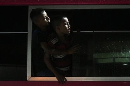 "Todos las noches salen hasta seis buses llenos [de migrantes] hacia la frontera. Van de 30 a 50 pasajeros" en cada uno, dijo el dependiente de la empresa de transporte que vendía los billetes. En la imagen, dos chicos hondureños miran por la ventana de un autobús que abandona San Pedro Sula, a 300 kilómetros de Tegucigalpa, y que viaja hacia la frontera de Guatemala.