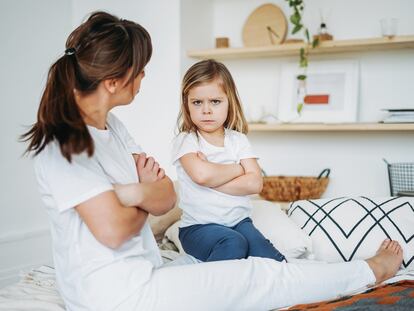 Una niña escucha con desconfianza a su madre.