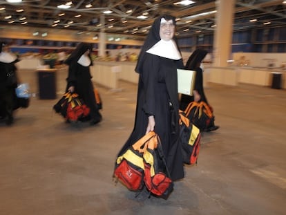 Un grupo de monjas recoge las mochilas que reparten los voluntarios.