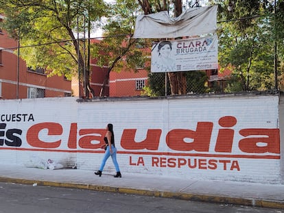 Una mujer camina frente a una barda con un mensaje en apoyo a Claudia Sheinbaum, en Ciudad de México, el pasado 13 de junio.