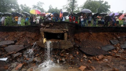 Varias personas permanecen cerca del lugar donde se ha derrumbado un muro en Bombay (India), este martes. Al menos 15 personas han muerto.