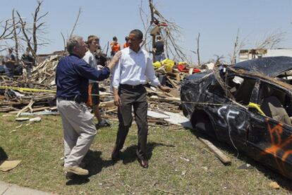 Barack Obama conversa con un vecino durante su visita a Joplin, la ciudad aún devastada por un terremoto que causó 139 víctimas la semana pasada.