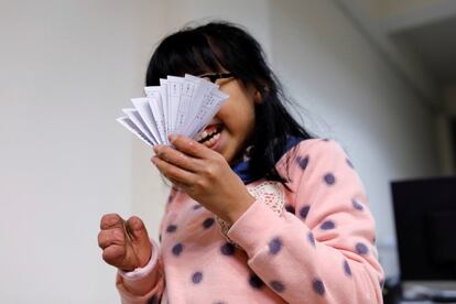 Angel Peng, 8, who injured her hand in a scalding accident when she was nine months old, reacts as she holds papers in Taoyuan, Taiwan, March 17, 2017. REUTERS/Tyrone Siu         SEARCH "PROSTHETIC 3D" FOR THIS STORY. SEARCH "WIDER IMAGE" FOR ALL STORIES.