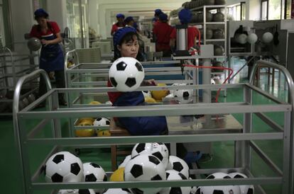 Una trabajadora ordena balones de fútbol en la recién abierta Fábrica de Equipamientos Deportivos en Pyongyang (Corea del Norte). 