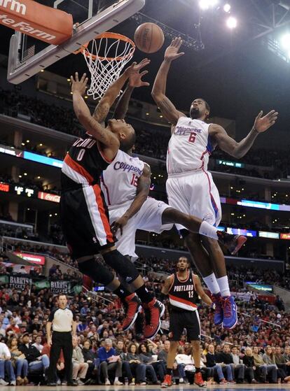 DeAndre Jordan (número 6) y Eric Bledsoe de Los Ángeles Clippers bloquean el lanzamiento de Damian Lillard de los Portland Trail Blazers.