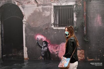 Una visitante mira las obras de arte en la reapertura de la exposición 'El segundo principio de un artista llamado Banksy', en Génova, Italia.