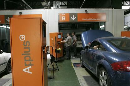 Dos operarios de Applus, en un centro de la ITV en Barcelona.