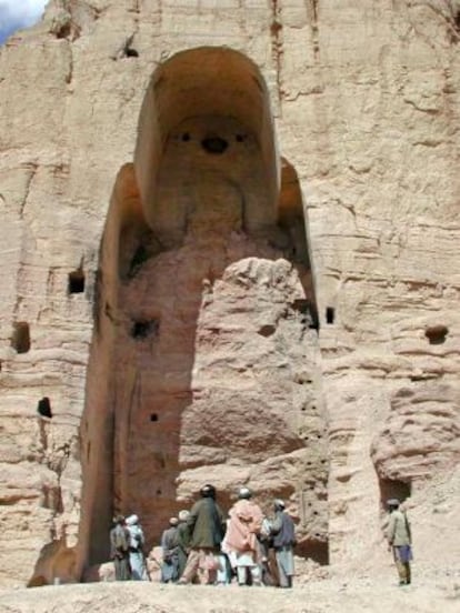 Talibanes armados ante el hueco en la roca que antes ocupaban los budas gigantes de Bamiyán, Afganistán, en 2001.