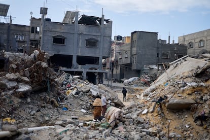 Varios palestinos caminaban entre los escombros de viviendas destruidas tras los ataques israelíes en Jan Yunis, este lunes. 