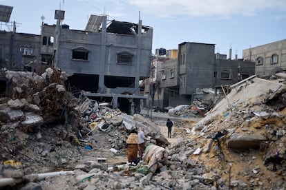 Varios palestinos caminaban entre los escombros de viviendas destruidas tras los ataques israelíes en Jan Yunis, este lunes.