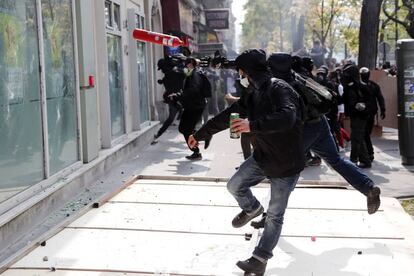 Un manifestante rompe los vidrios de un comercio durante una manifestación de los sindicatos y de los "chalecos amarillos" para conmemorar el Día Internacional de los Trabajadores, este miércoles, en París (Francia).