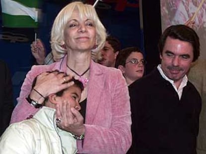 Teófila Martínez abraza a un niño, ayer, en presencia de José María Aznar.