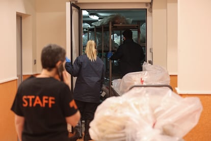 Araceli Borbolla, técnica de la sala de disección, habla por teléfono mientras los operarios trasladan cuerpos en el Centro de Donaciones de Cuerpos y Salas de Disección (CDSD) de la Universidad Complutense de Madrid. La cámara de congelación está a -20º C.