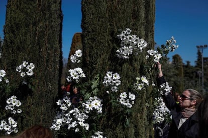 Una persona coloca flores en el Bosque del Recuerdo del parque de El Retiro de Madrid, con motivo del quince aniversario de la masacre terrorista.