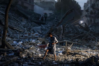 Un hombre camina sobre los escombros de una torre destruida en un ataque aéreo israelí en Gaza.