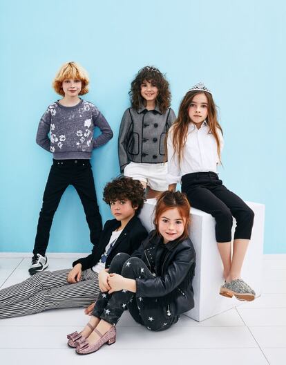 De pie, a la izquierda, Pablo lleva ‘jeans’ negros de Karl Lagerfeld Kids, sudadera de Pepe Jeans y deportivas de Karl Lagerfeld Kids. En el centro, Daniela luce chaqueta de cheviot de Dsquared2, ‘shorts’ de Polo Ralph Lauren y tiara de Claire’s. A la derecha, Aroa viste camisa de Tommy Hilfiger, pantalón de Carrément Beau, zuecos en piel de serpiente de Bonpoint y tiara de Claire’s. Sentado, Rodrigo con ‘blazer’ de Karl Lagerfeld Kids y camiseta con dibujo de un rayo y ‘jeans’, ambos de Zadig & Voltaire. A su lado, Arrieta lleva ‘perfecto’ de cuero de IKKS, pantalones con estampado de estrellas de Mango Kids, jersey de rayas bicolor de Kiabi y manoletinas de purpurina rosa con lazo de Pretty Ballerinas.