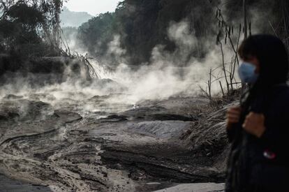Un aldeano observa un arroyo de lava humeante tras la erupción del volcán Semeru, en Lumajang (Indonesia). El volcán expulsó este martes una columna de humo y ceniza de hasta 2.000 metros por encima del cráter.